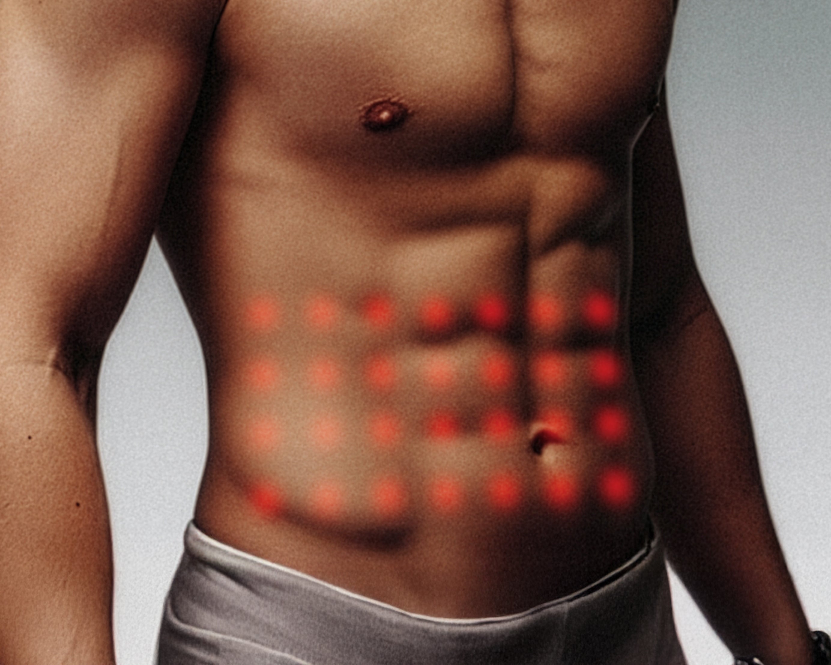 Man's torso with red dots indicating pressure points of red light therapy on a gray background