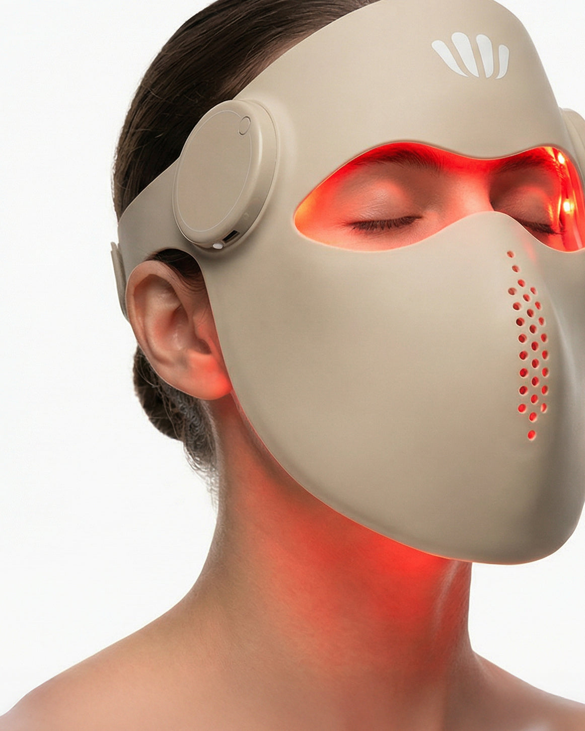 Person wearing a beige facial mask with red light therapy on a white background